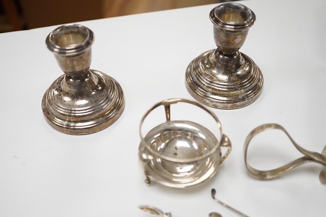 A small quantity of assorted small silver and plated flatware, a small silver stand, a silver napkin ring and a pair of modern silver mounted dwarf candlesticks.